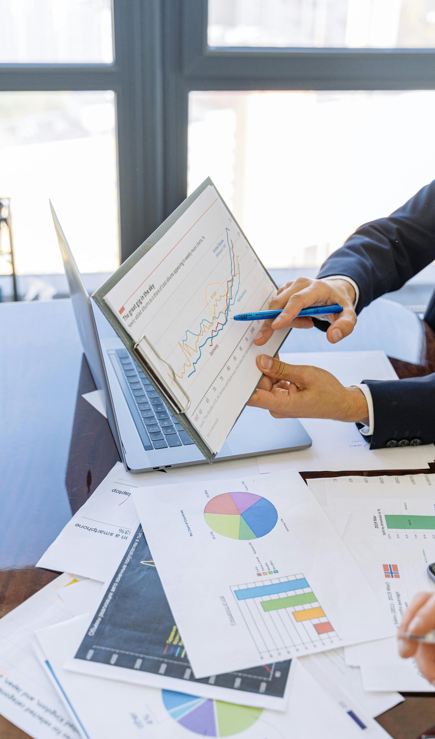 Business professionals discussing financial graphs and charts in an office setting.